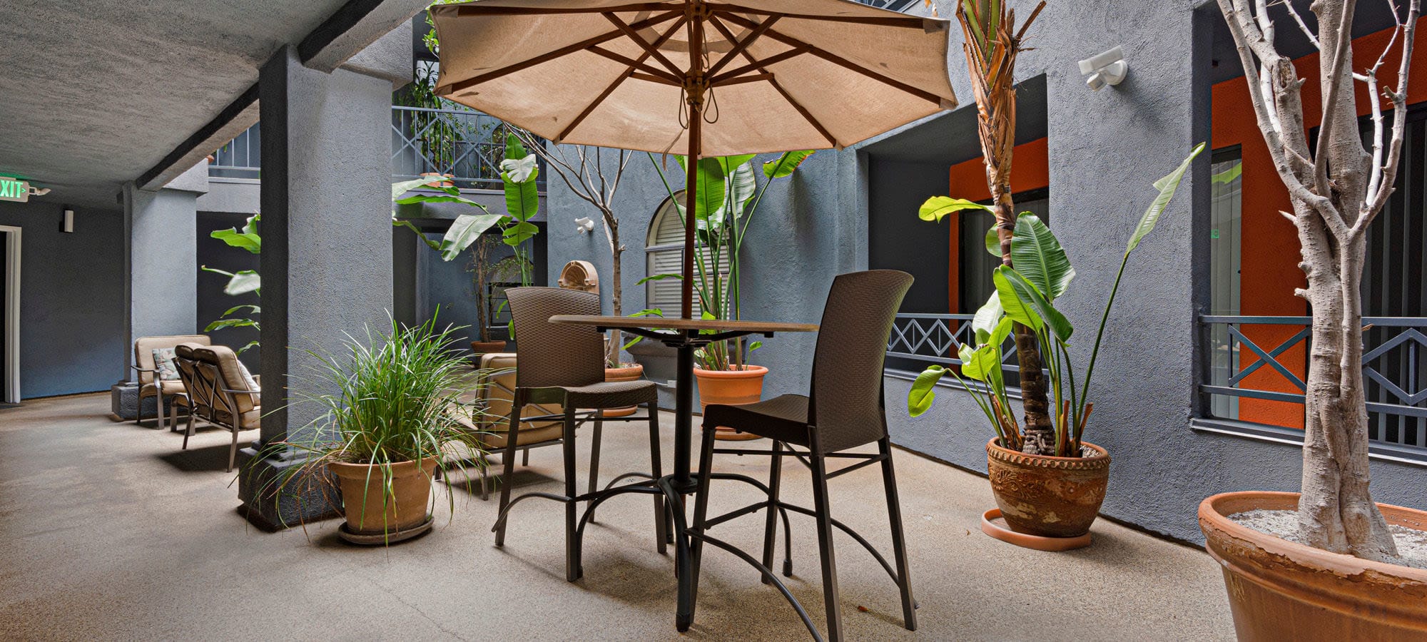 Exterior courtyard area with lots of seating and sun coverings at The Jeremy in Los Angeles, California