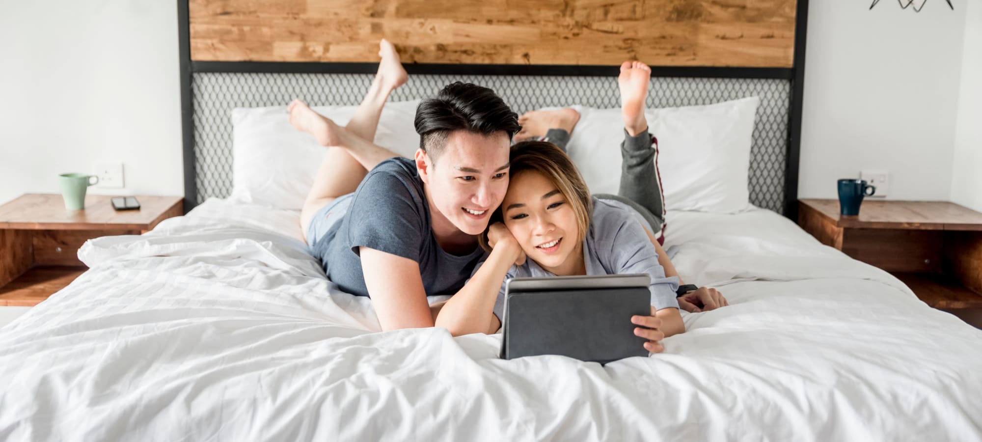 Couple laying on their bed at Canopy at Cottonwood in Casa Grande, Arizona
