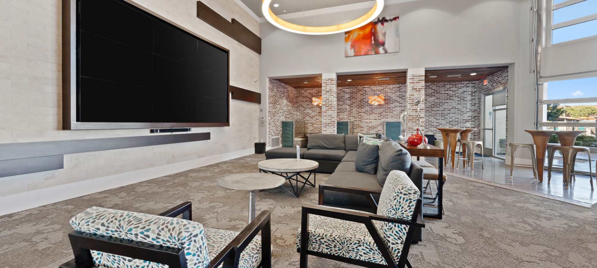 Comfortable seating in front of the large flatscreen TVs in the clubhouse at The Hyve in Tempe, Arizona