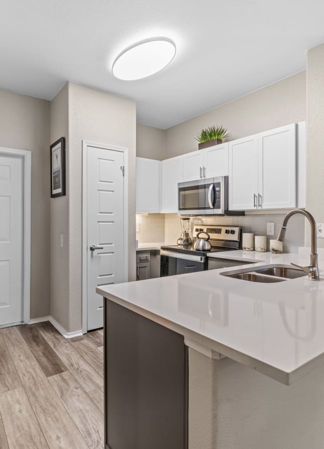 High-end kitchen with quartz countertops and designer cabinetry at Montrachet Apartment Homes in Lakewood, Colorado