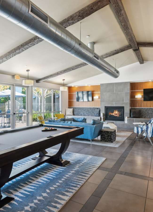Resident clubhouse with a billiards table and a fireplace at Azure Apartment Homes in Petaluma, California