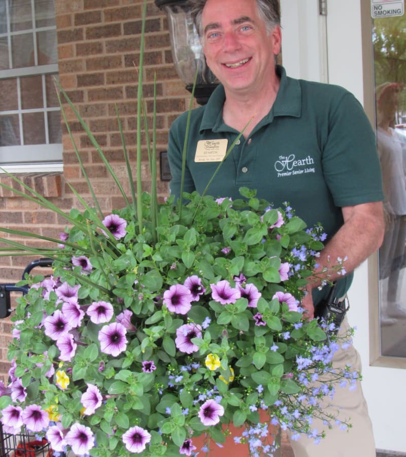 Ed H. Holding some potted flowers at a Hearth Management community