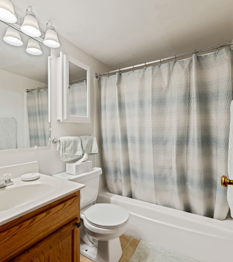 A well lit Bathroom with a fabric shower curtain at University Heights in Charlottesville, Virginia