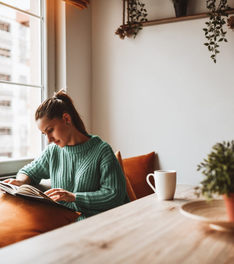 Woman reading in her modern apartment at Springhouse Townhomes in Allentown, Pennsylvania