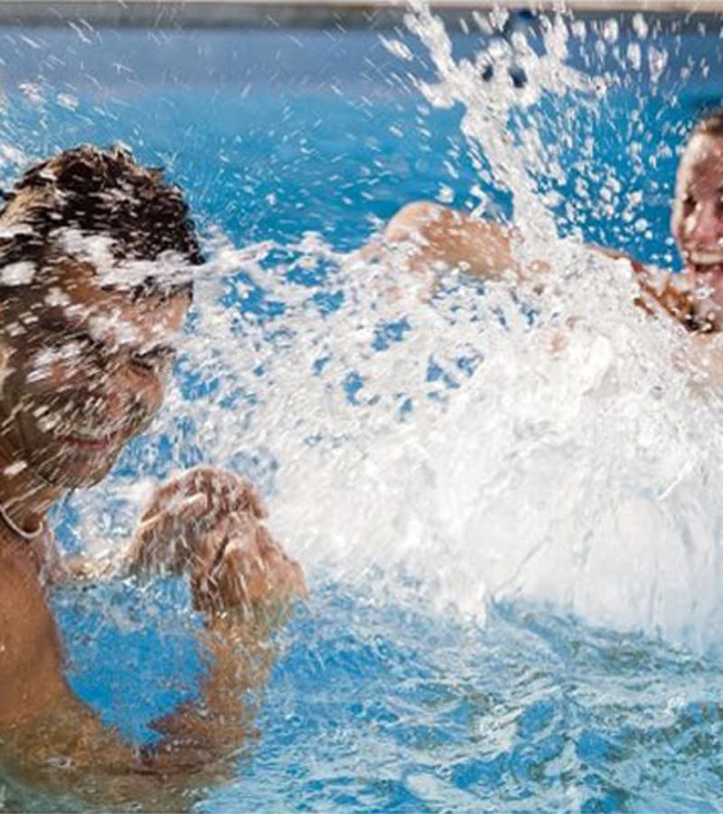 Happy friends swimming in pool at DaVinci Apartments in Davis, California