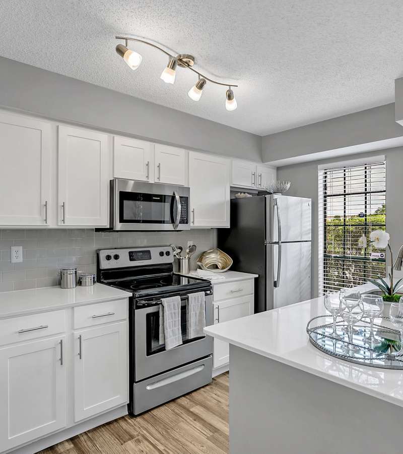 Modern kitchen with wooden cabinets, stainless-steel appliances at Rosemont Windermere in Orlando, Florida