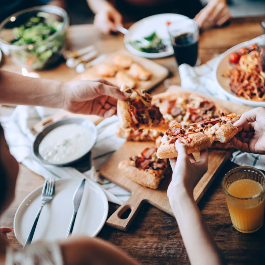 Residents eating pizza and sharing a meal near The Adair in Charlotte, North Carolina