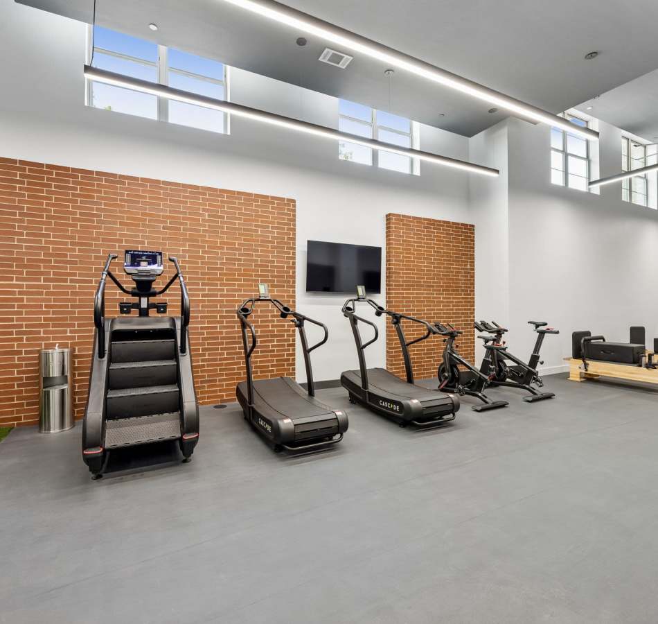 Fitness center with cardio machines at The Margaret at Riverfront in Dallas, Texas