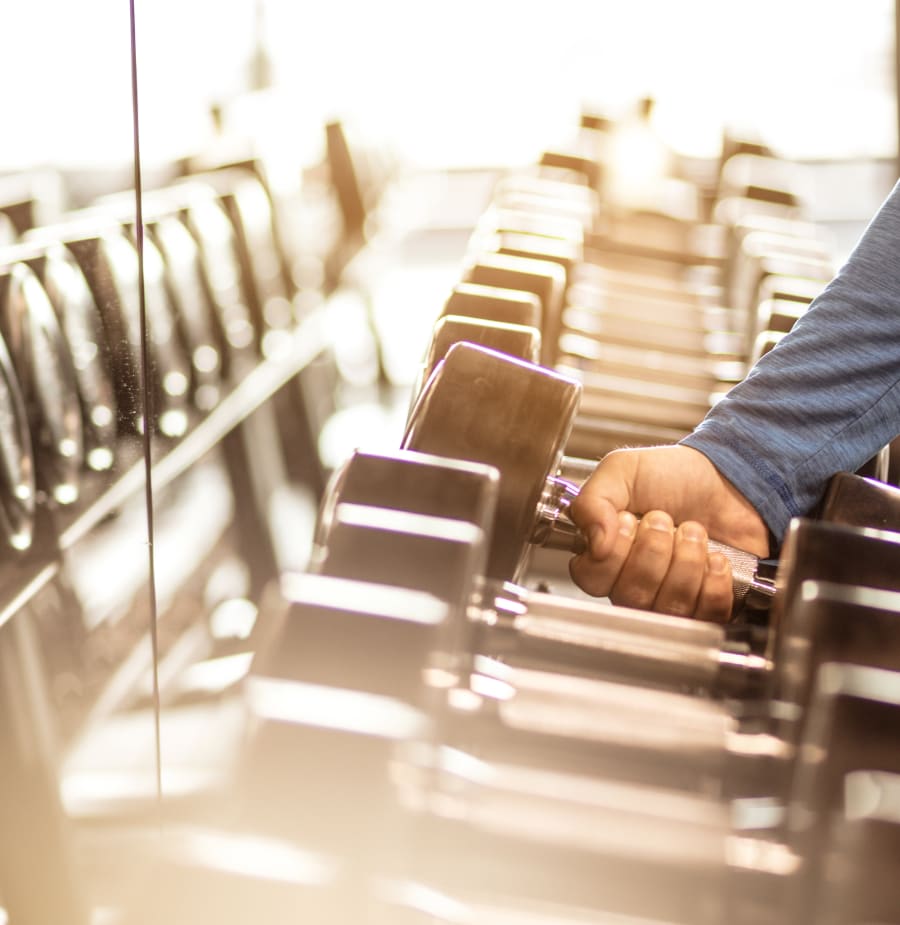 Resident grabbing a dumbbell at Oaks Braemar in Edina, Minnesota