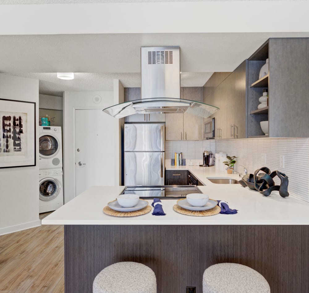 Quartz countertops and espresso wood cabinetry in a model home's kitchen at Tower 801 in Seattle, Washington