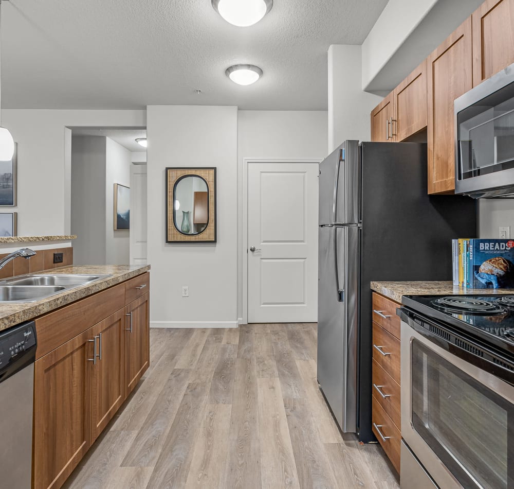 Modern kitchen with granite countertops with counter seating at The Jones in Hillsboro, Oregon