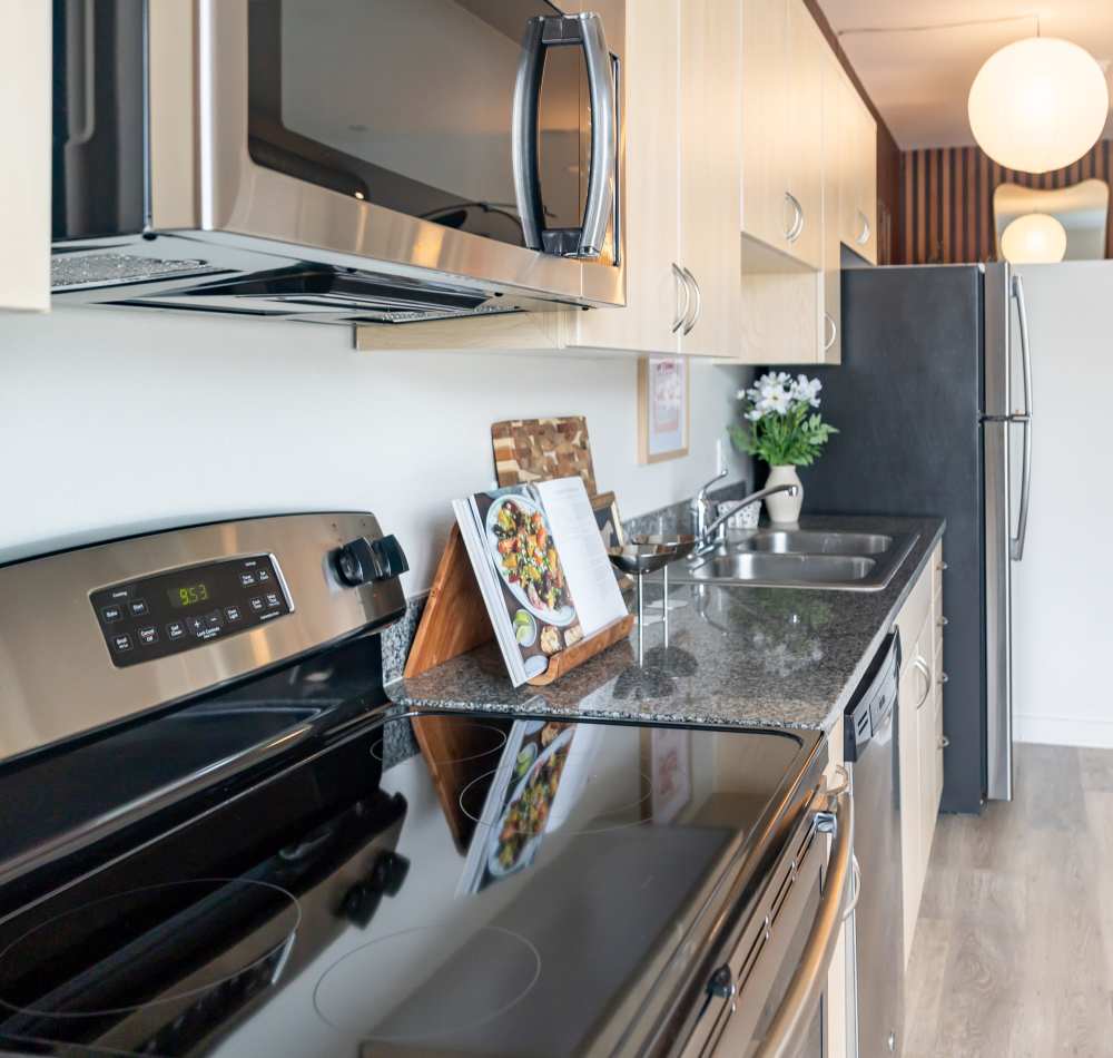 Updated kitchen with stainless steel appliances, including refrigerator and dishwasher at Nova Apartment Homes in San Diego, California