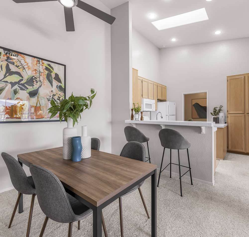 Split view of the dining and kitchen areas from the living space of a model home at Sofi Canyon Hills in San Diego, California