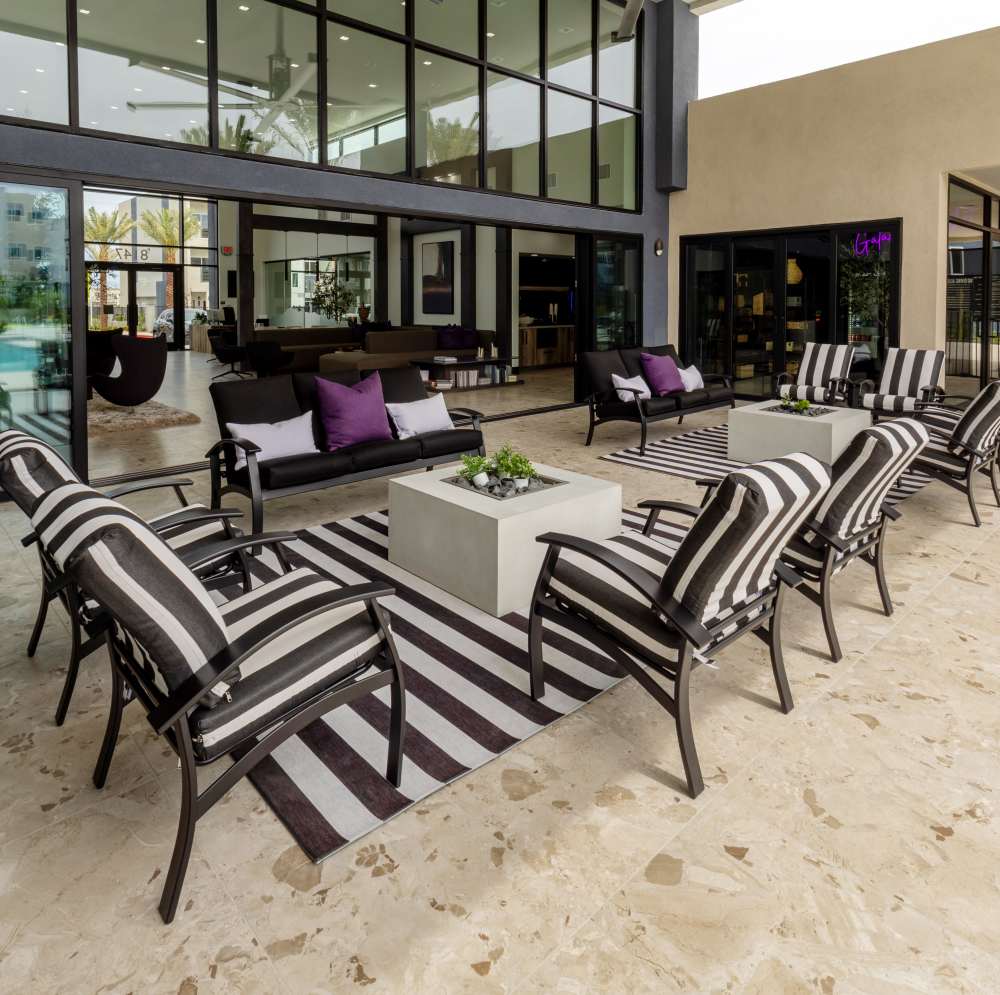 Seating area with striped chairs and table at Continuum Apartments in Las Vegas, Nevada