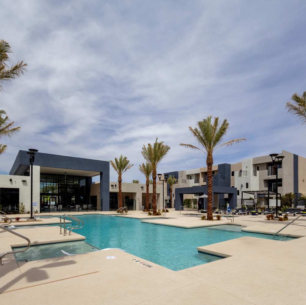 Swimming pool with palm trees and lounge chairs at Continuum Apartments in Las Vegas, Nevada