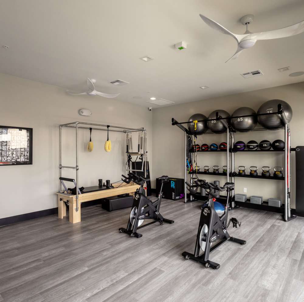 Exercise equipment arranged on gray flooring at Continuum Apartments in Las Vegas, Nevada