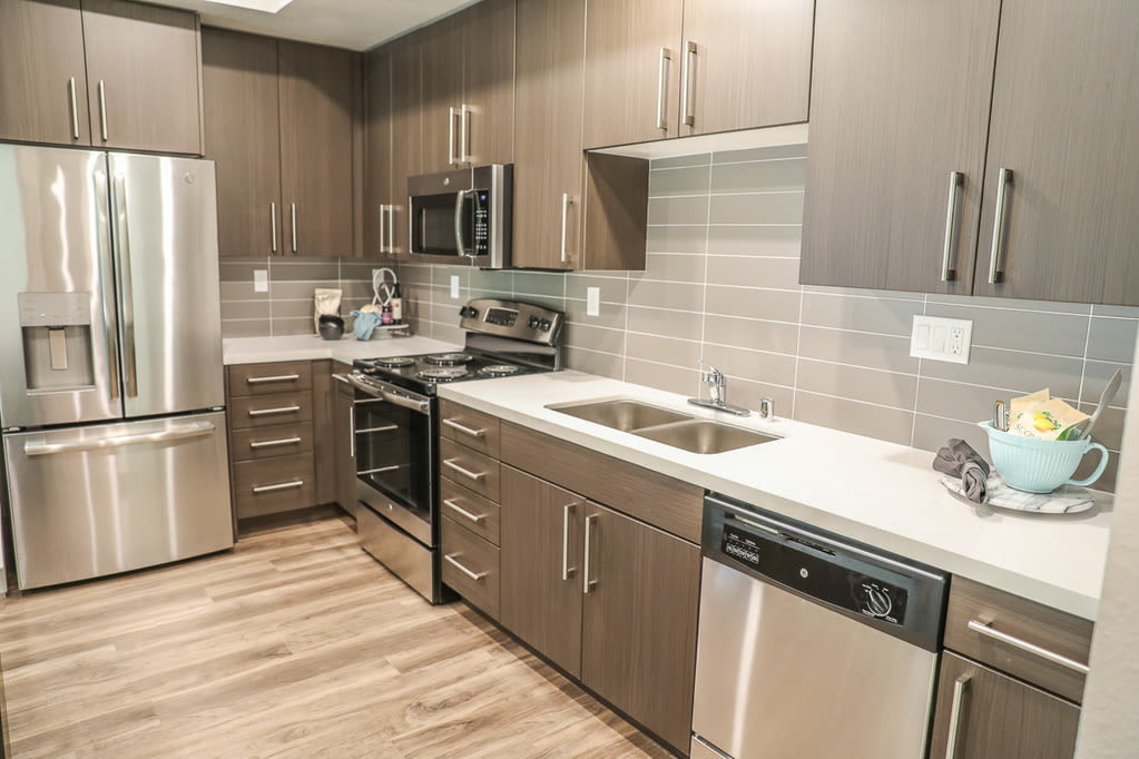 Kitchen with white appliances and cabinets at Sutter Green Apartments, Sacramento, California