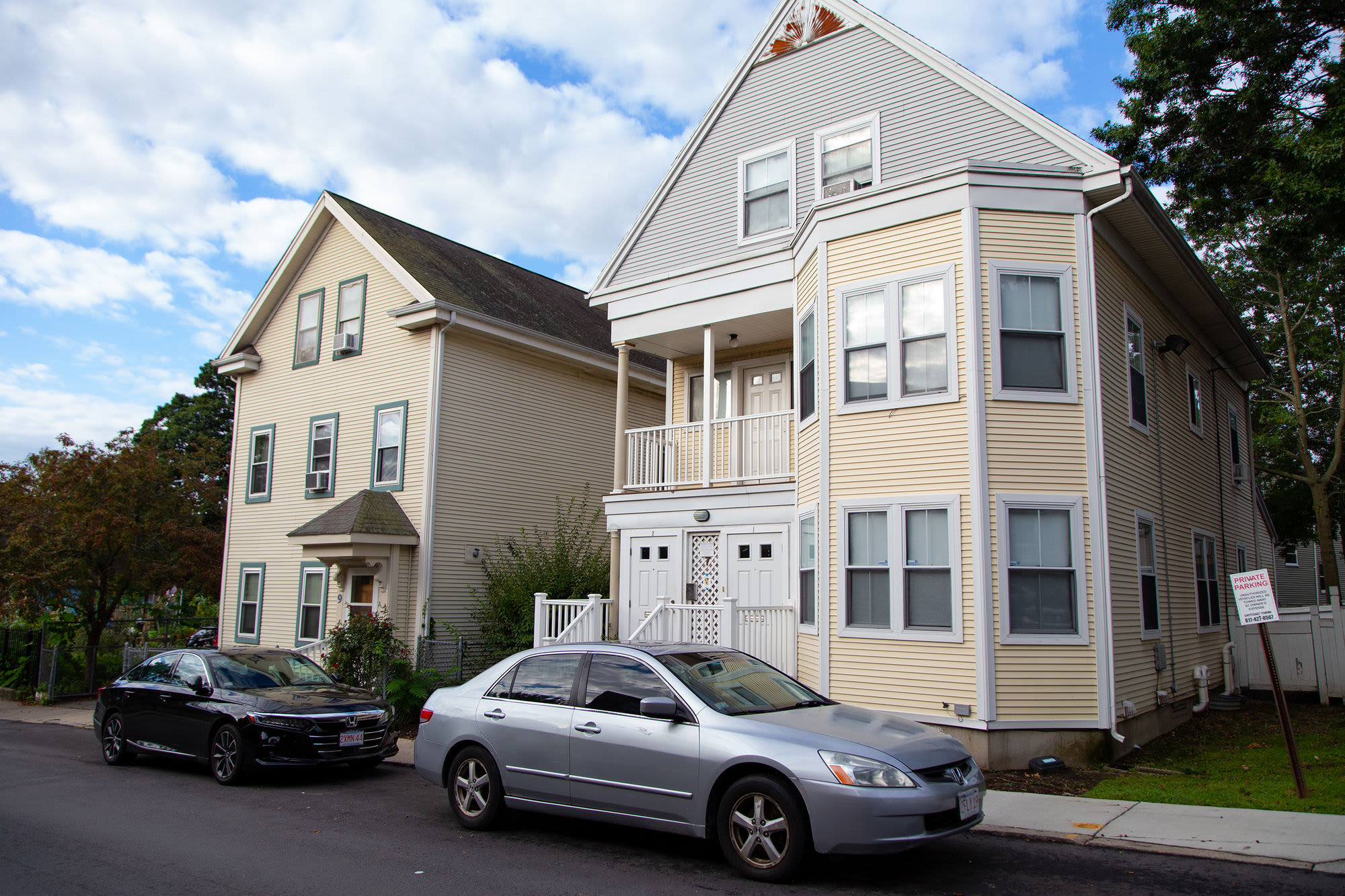 Exterior view of the apartment building with parked cars at Hyde Square Coop in Jamaica Plain, Massachusetts
