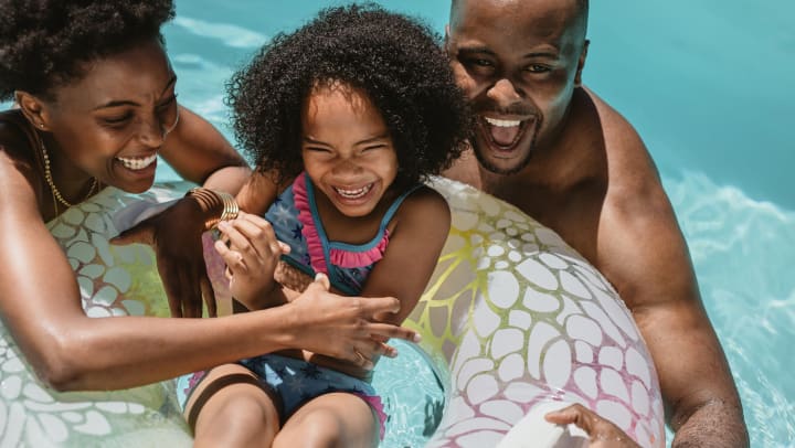 A family playing in the pool and laughing