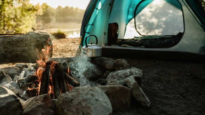 Campsite with a tent and a fire burning 