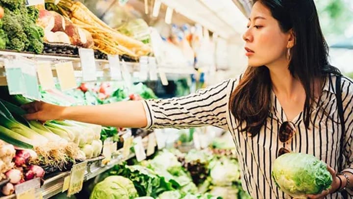 Woman picking out veggies at the grocery store 