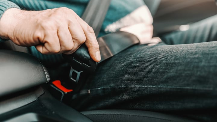Senior man fastening seatbelt