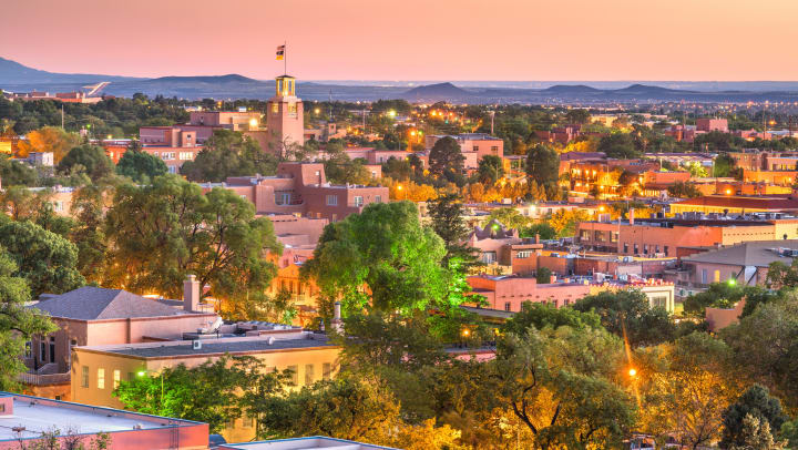 An aerial view of the city of Sante Fe with many buildings and mountain terrain in the background
