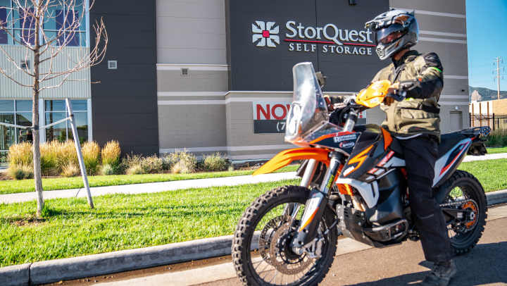 Motorcyclist riding in front of Storquest building