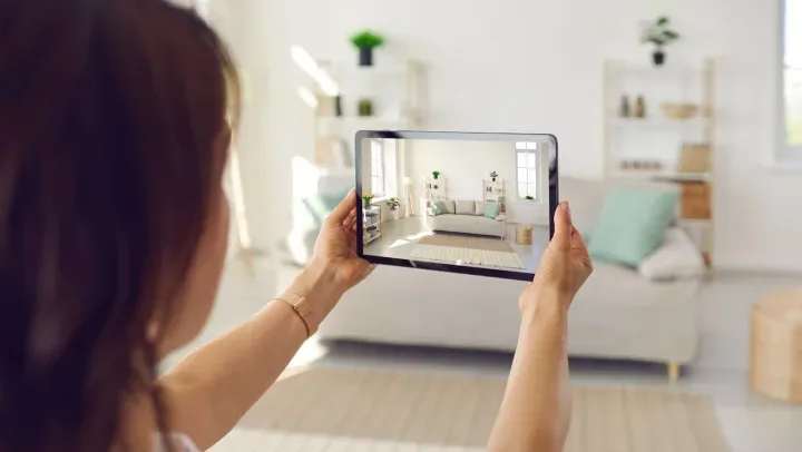 Woman taking a photo of her used couch to sell online 
