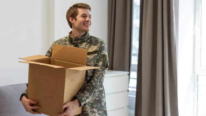 Soldier holding a moving box and getting ready for military deployment