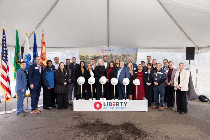 Liberty Military Team Members stand in front of shovels and hardhats in a celebratory photo of the Joint Base Lewis McChord Groundbreaking