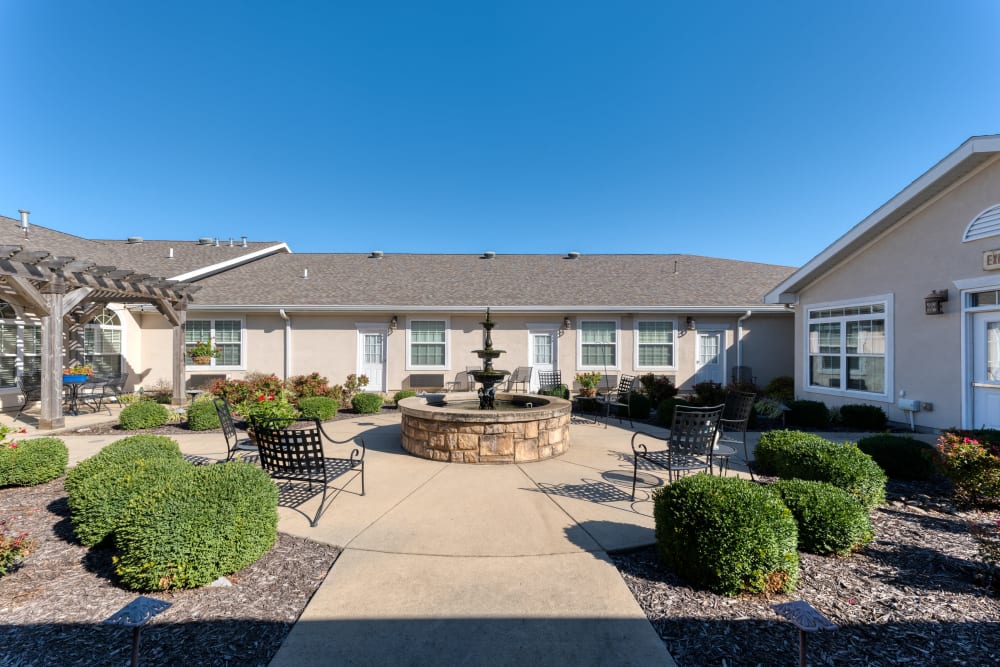 Courtyard with green lawn and paved walkway at Addington Place of Lee's Summit in Lees Summit, Missouri