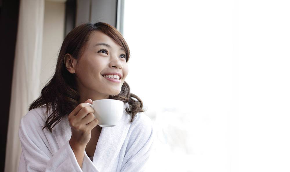 Woman enjoying a warm beverage at luxury apartments