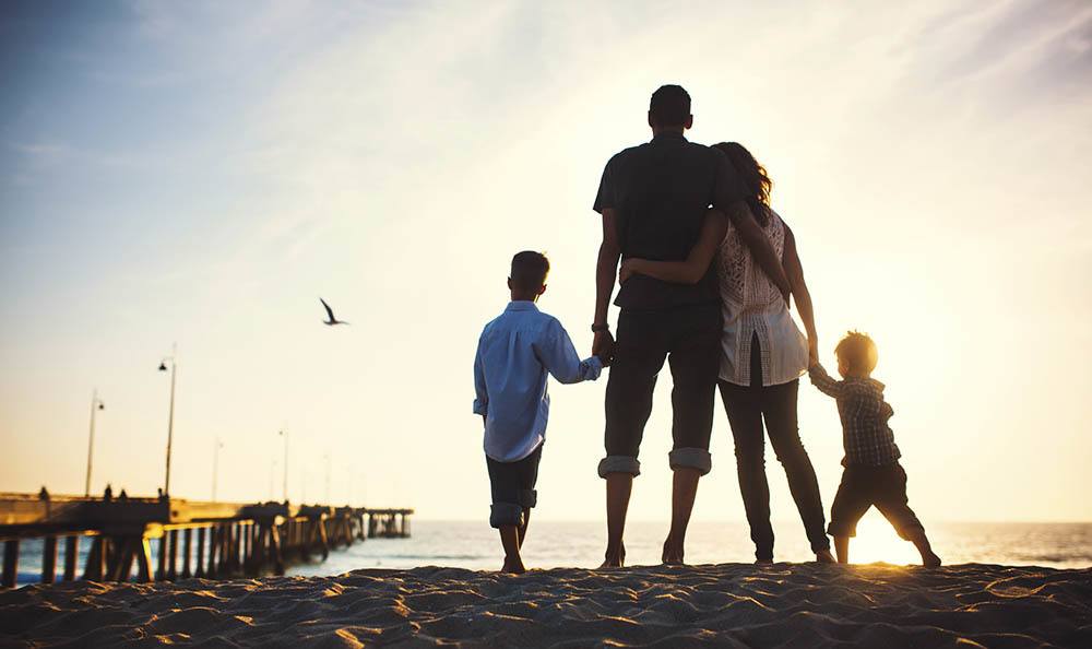 Beautiful family at the beach at sunset