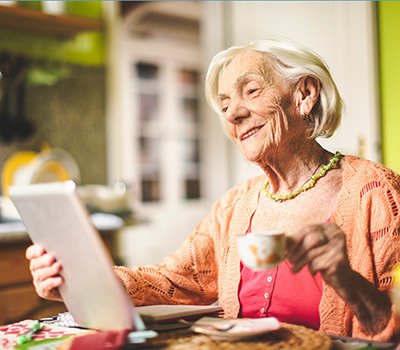 Woman reads a tablet with breakfast about all of Randall Residences' helpful reference links.