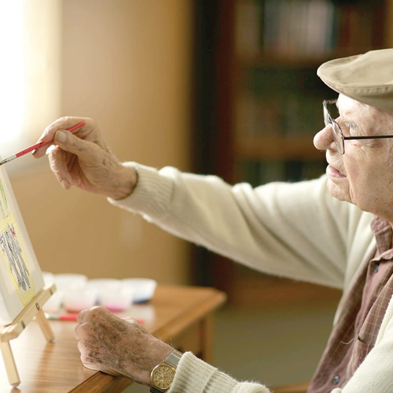 A resident paints at HarborChase senior living.