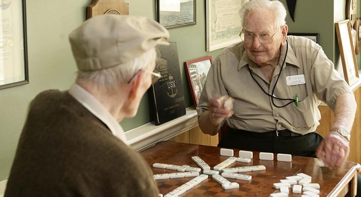 HarborChase residents play dominoes