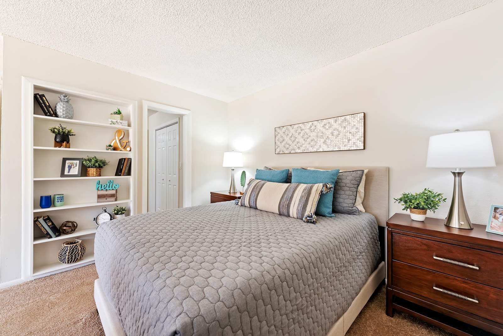 Comfortably furnished bedroom with built-in bookcase at Executive Apartments in Miami Lakes, Florida