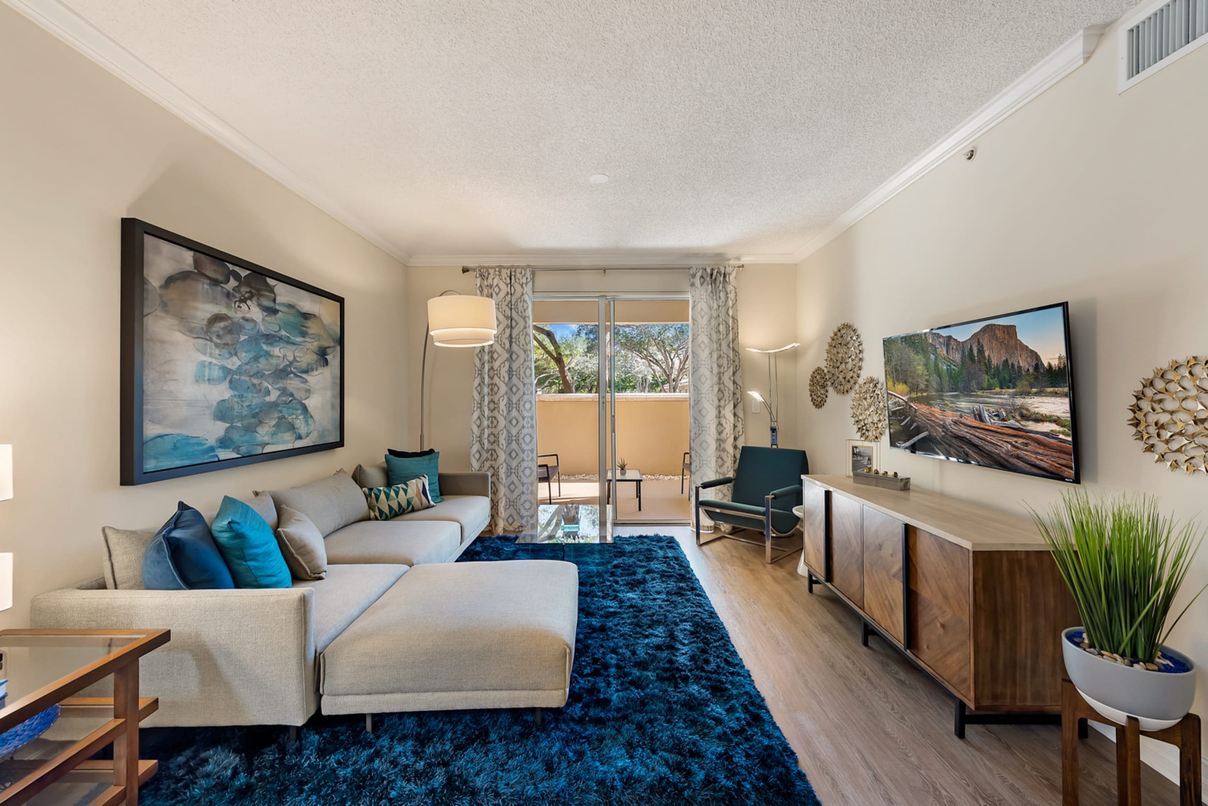 Beautiful model living room with attached private patio area at Fountain House Apartments in Miami Lakes, Florida