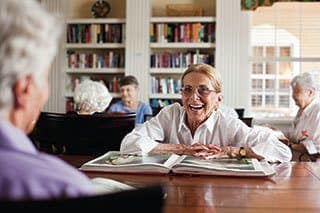 Senior living residents enjoying our private library collection in Naples