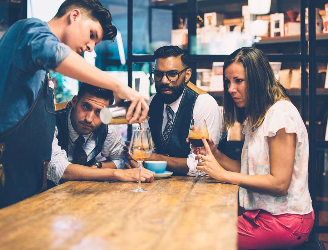 People wathcing bartender pour coffee near The Addison in Brandon