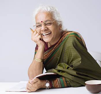 Lady sitting at table with a tea cup laughing