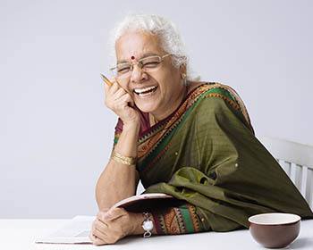 Lady sitting at table with a tea cup laughing at The Pearl at Fort Mill in Fort Mill, South Carolina