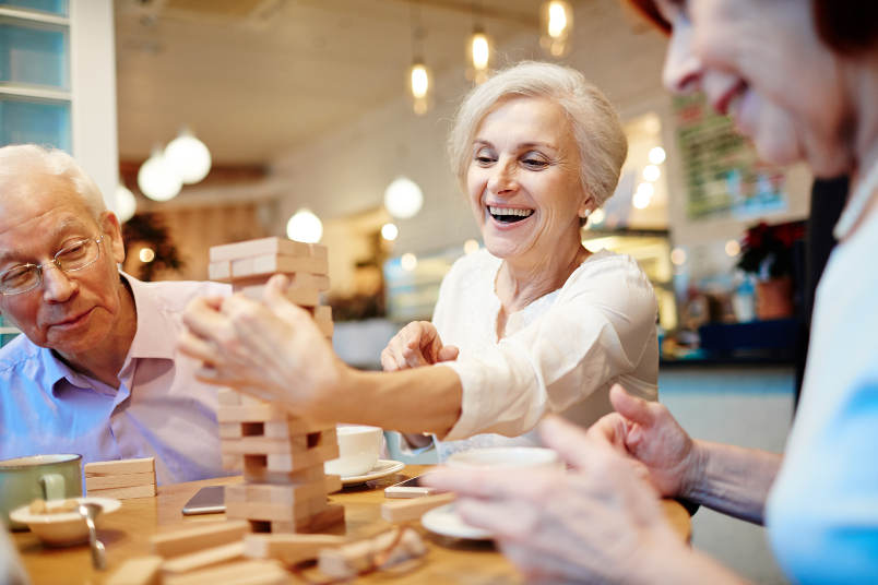 Happy serniors playing Jenga at Regency Fallbrook in Fallbrook, California.