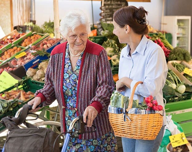 Resident grocery shopping with the help of a caretaker in Maitland, FL