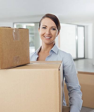 A woman carrying boxes to Roadrunner Self Storage in Las Cruces, New Mexico