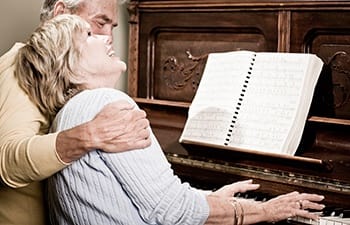 Jovial couple entertaining themselves with the piano at one of our Grand Villa Senior Living communities.