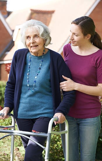 Loving daughter helping her mother as they walk the grounds and enjoy the day at one of our AssistedSenior.com communities