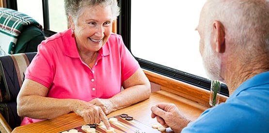 Couple enjoying a game of backgammon at one of our Grand Villa Senior Living communities