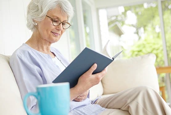 Senior woman enjoying a good book in a quiet spot here at Grand Villa of Clearwater in Florida